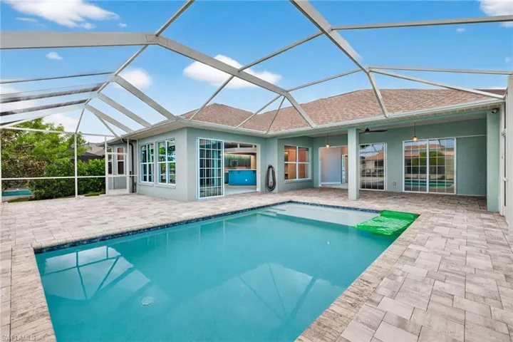 Outdoor pool featuring a sunroom, glass enclosure, a patio area, and a ceiling fan