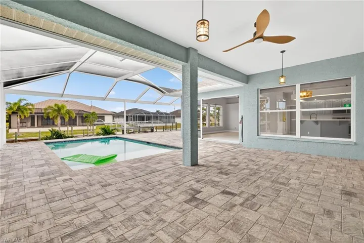 Outdoor pool featuring a patio area, a ceiling fan, a lanai, a sunroom, and a residential view