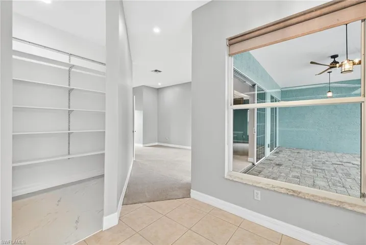 Hall with recessed lighting, light carpet, and light tile patterned floors