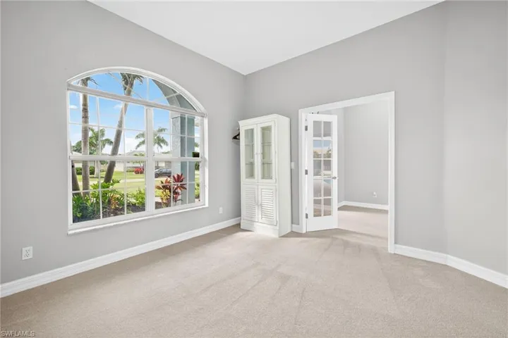 Empty room featuring light colored carpet and baseboards