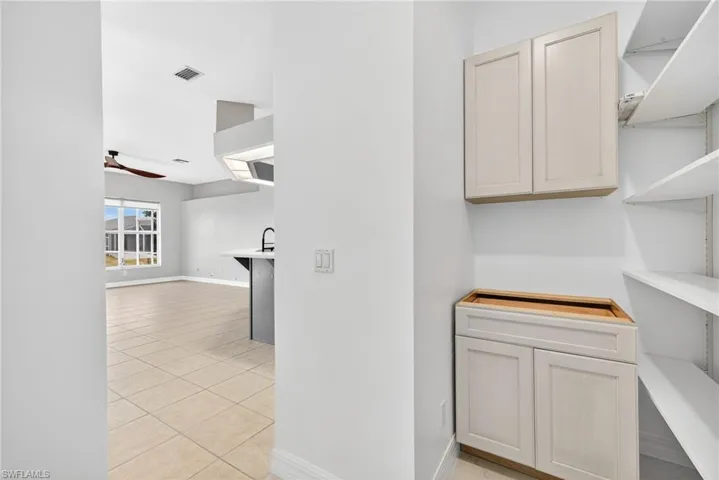 Hallway featuring light tile patterned flooring and baseboards