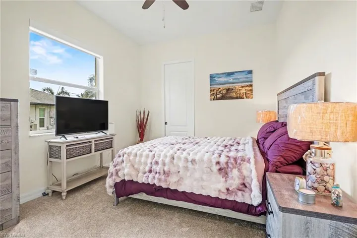 Bedroom featuring light carpet and a ceiling fan
