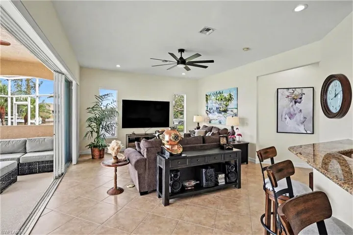 Living area featuring ceiling fan, light tile patterned floors, and recessed lighting