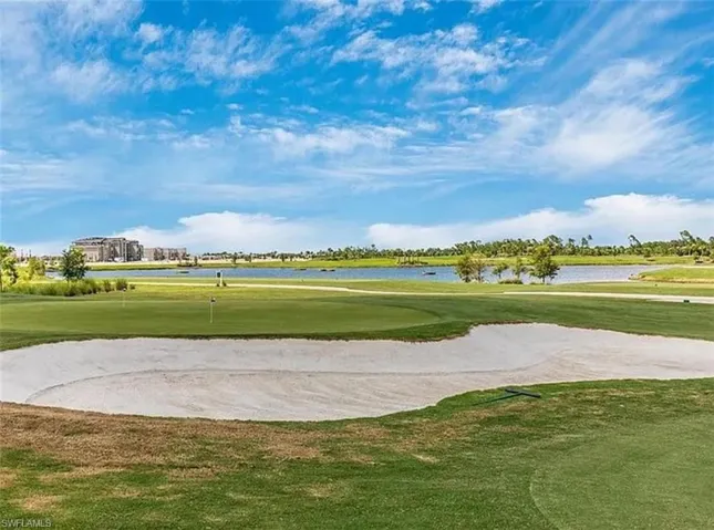 View of community with golf course view, a water view, and a putting green