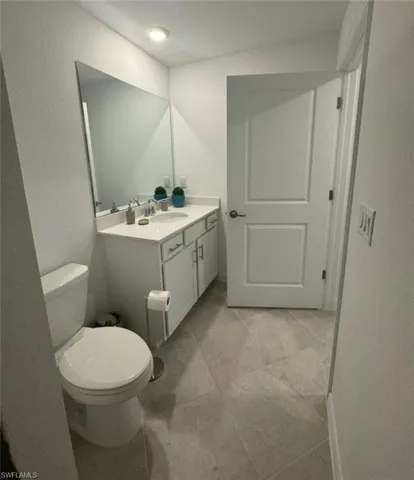 Half bathroom featuring vanity and a textured wall