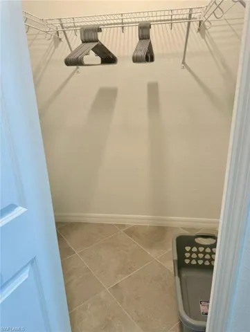 Walk in closet with light tile patterned floors