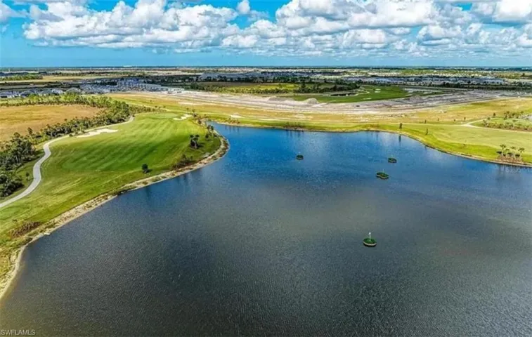 Drone / aerial view of a nearby body of water and a local golf course