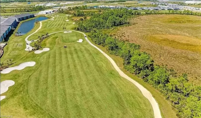 Drone / aerial view of a golf course and a nearby body of water