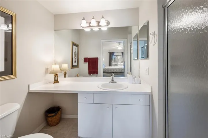 Full bathroom with vanity, connected bathroom, light tile patterned floors, an enclosed shower, and a ceiling fan
