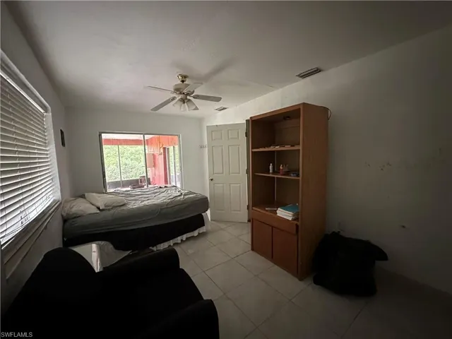 Bedroom with ceiling fan and light tile patterned floors