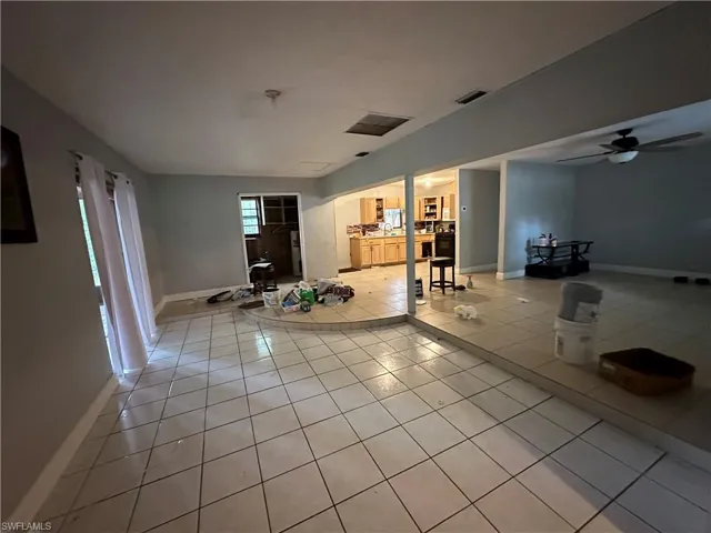 Unfurnished living room with light tile patterned floors and ceiling fan