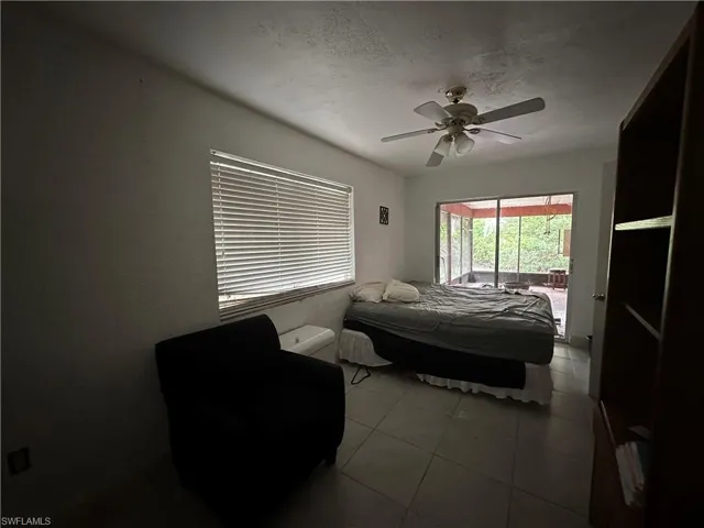 Bedroom featuring access to outside, ceiling fan, and tile patterned floors