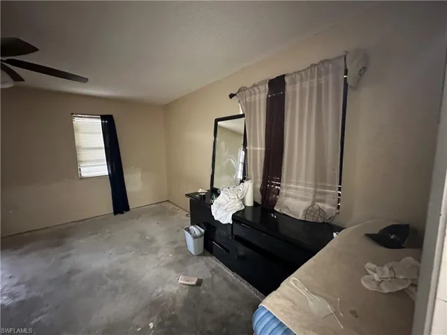 Unfurnished bedroom with ceiling fan and concrete floors
