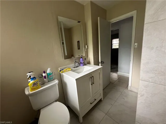 Bathroom with tile patterned flooring, toilet, and vanity