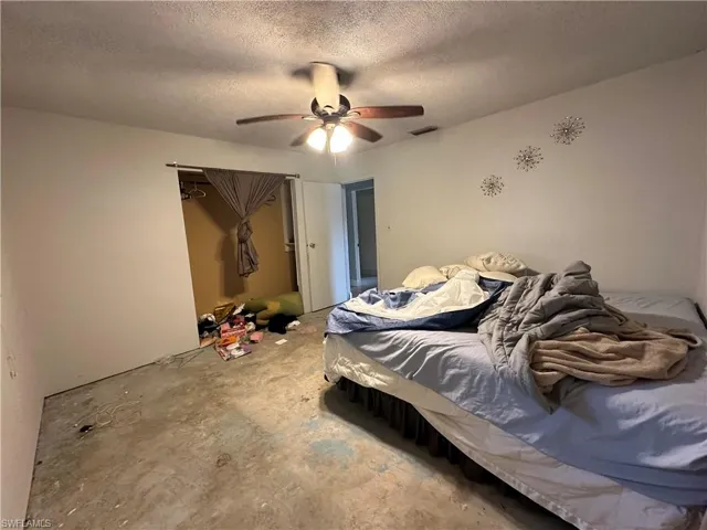 Bedroom with a textured ceiling and ceiling fan