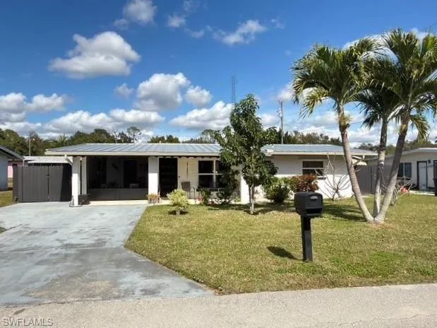 Ranch-style house featuring a front yard and concrete driveway