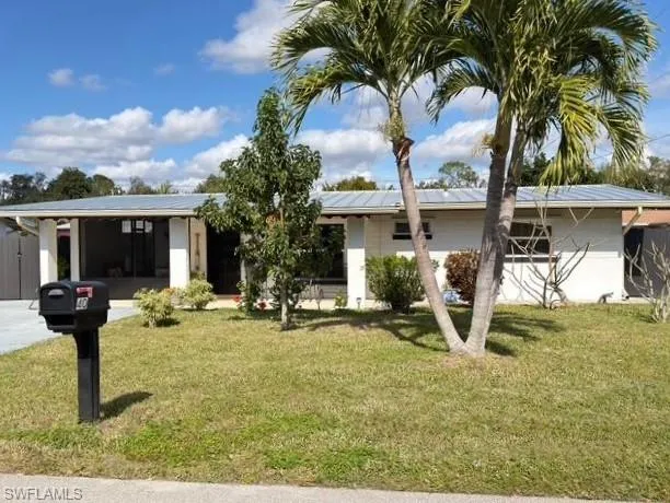 Single story home featuring a front yard and solar panels