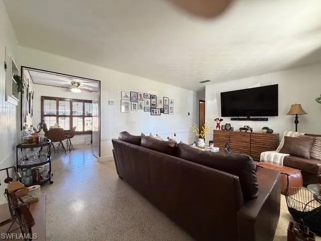 Living room featuring speckled floor and a ceiling fan