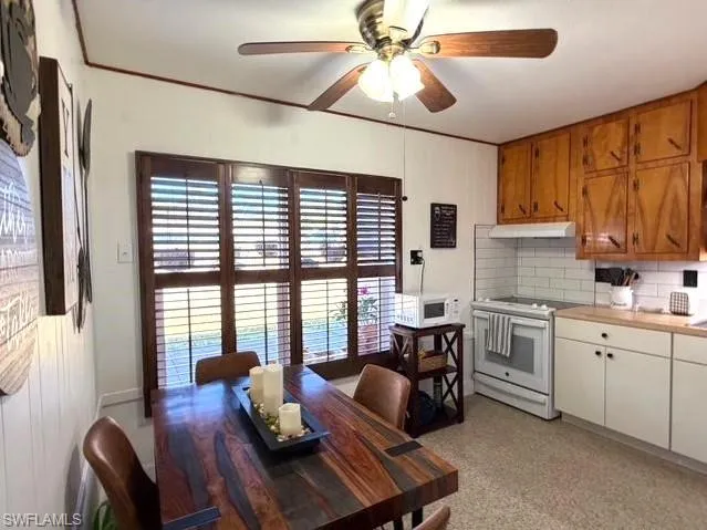 Dining space featuring a ceiling fan and dark speckled floor