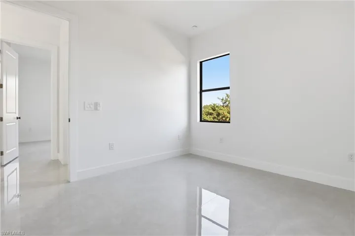 Unfurnished room featuring concrete floors and baseboards