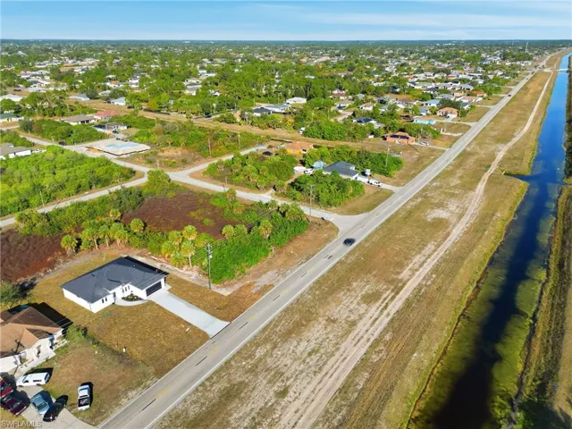 Aerial view of property and surrounding area with nearby suburban area