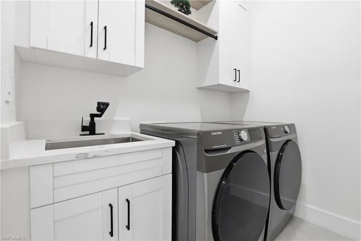 Washroom with washing machine and clothes dryer and cabinet space