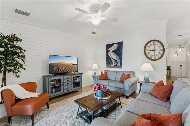 Living room featuring ceiling fan and ornamental molding
