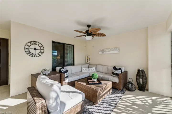 Living room with light carpet and ceiling fan