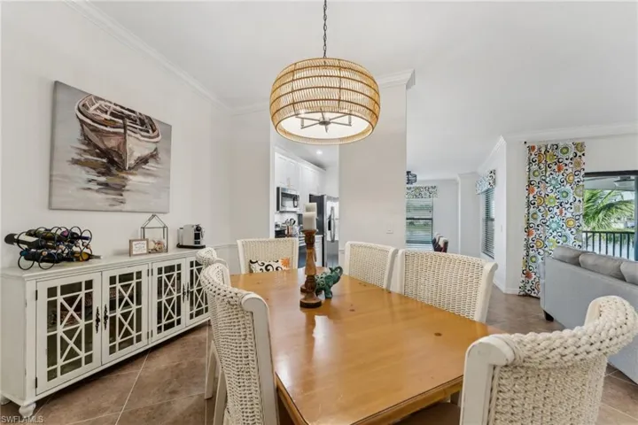 Dining space with tile patterned floors and ornamental molding