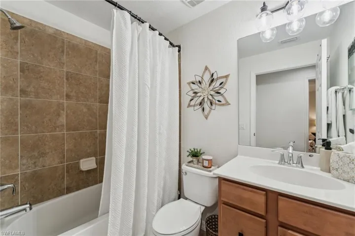 Full bathroom featuring shower / bath combo, vanity, and toilet