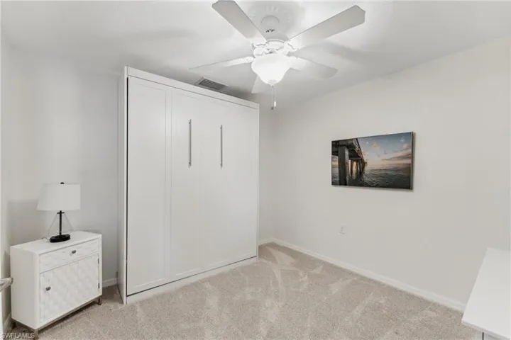 Unfurnished bedroom with light colored carpet, ceiling fan, and a closet