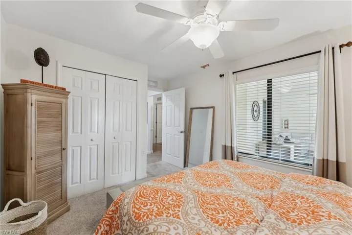 Bedroom featuring light carpet, a closet, and ceiling fan