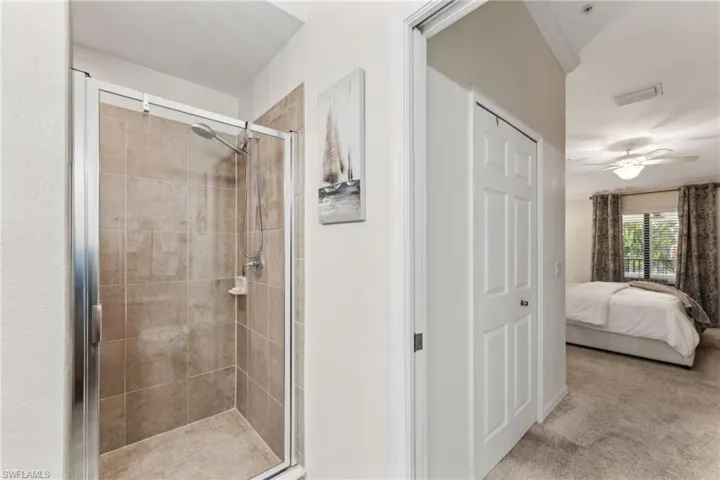 Bathroom featuring an enclosed shower and ceiling fan