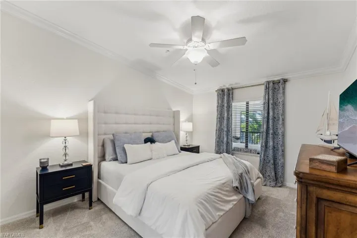 Bedroom featuring crown molding, light colored carpet, and ceiling fan