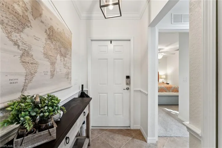 Tiled entrance foyer featuring crown molding and ceiling fan