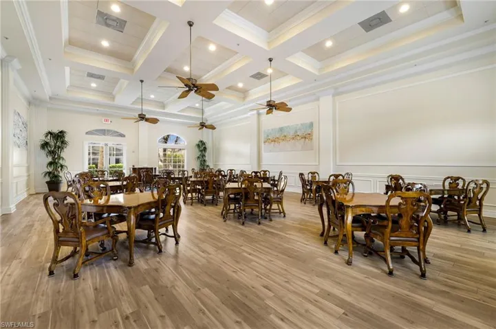 Dining space, a decorative wall, light wood finished floors, and beamed ceiling
