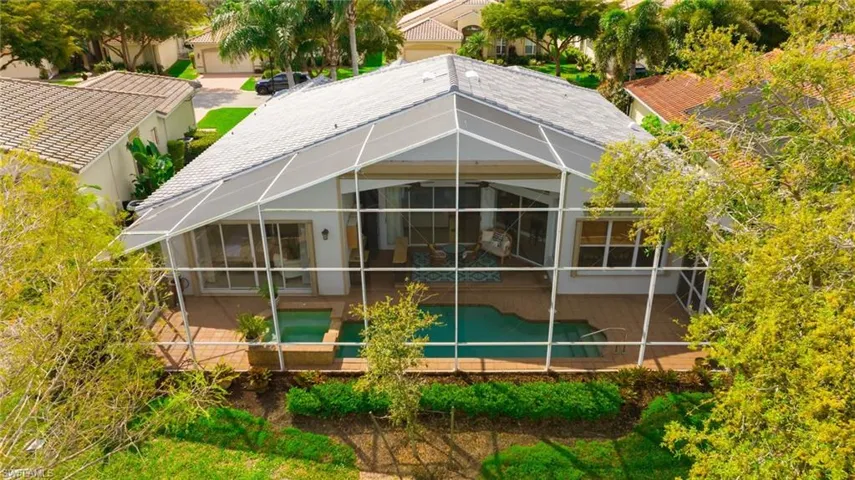 Rear view of house featuring a covered lanai area, pool and spa