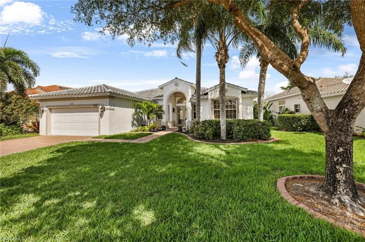 Mediterranean / spanish home featuring a garage, stucco siding, driveway, and a front yard