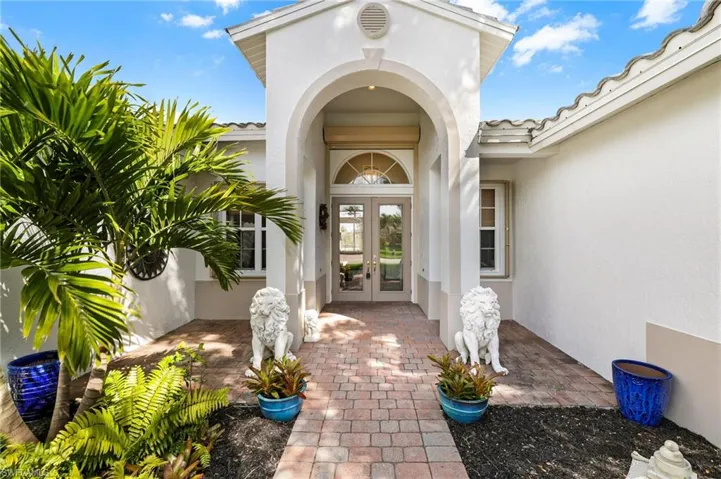 Property entrance featuring a tiled roof, french doors, and stucco siding