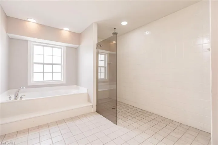 Bathroom featuring tile patterned flooring and separate shower and tub