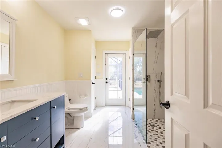 Bathroom with toilet, walk in shower, and vanity