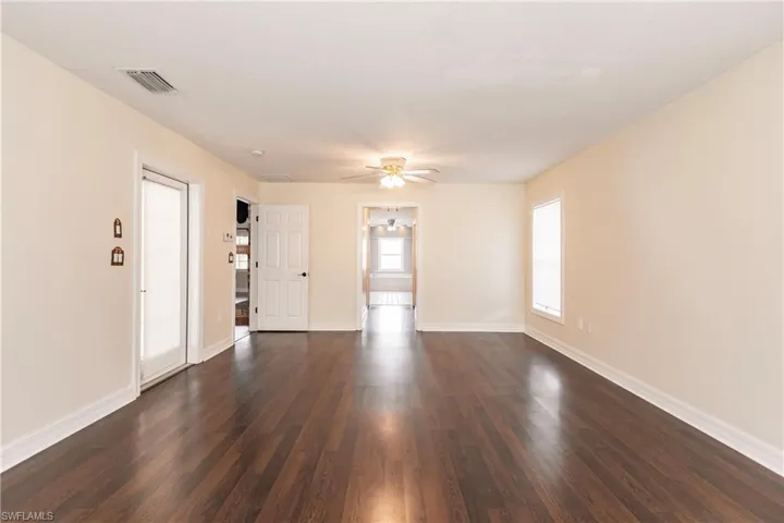 Unfurnished room featuring ceiling fan and dark hardwood / wood-style floors