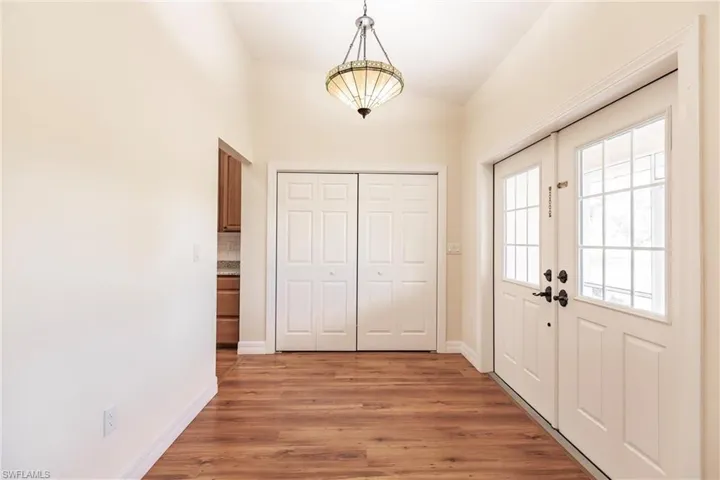 Doorway featuring french doors, vaulted ceiling, and hardwood / wood-style flooring
