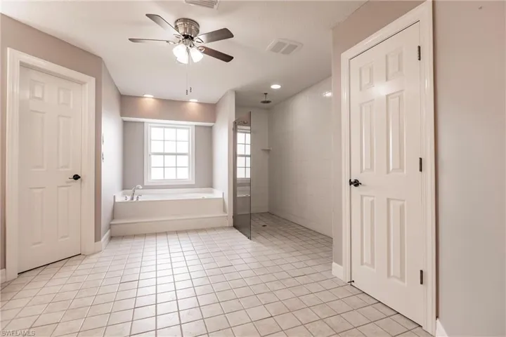 Bathroom featuring tile patterned flooring, ceiling fan, and independent shower and bath