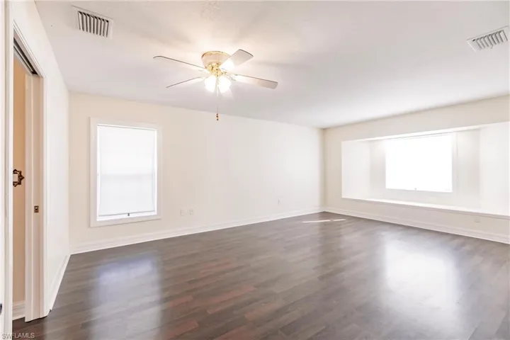 Unfurnished room with ceiling fan and dark hardwood / wood-style floors
