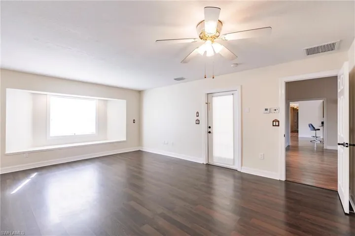 Unfurnished room with ceiling fan and dark hardwood / wood-style floors