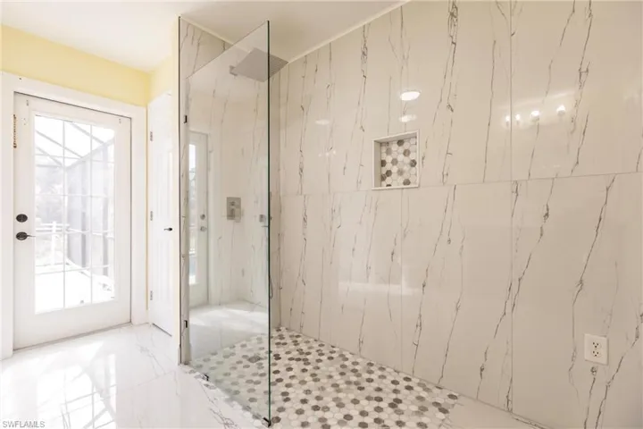 Bathroom featuring tiled shower and a healthy amount of sunlight