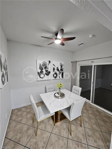 Dining area featuring light tile patterned flooring, baseboards, visible vents, and a ceiling fan