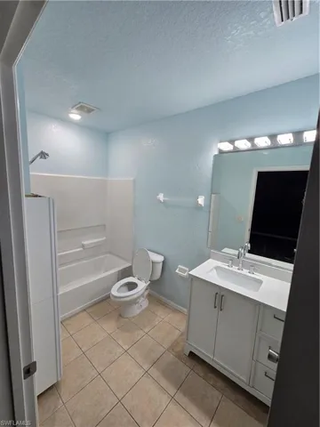 Bathroom featuring toilet, vanity, visible vents, and tile patterned floors