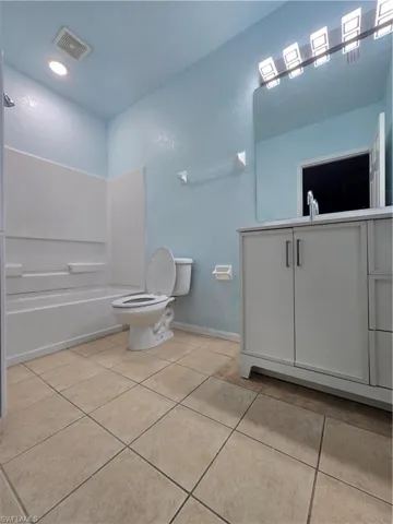 Full bath featuring tile patterned flooring, baseboards, visible vents, and toilet